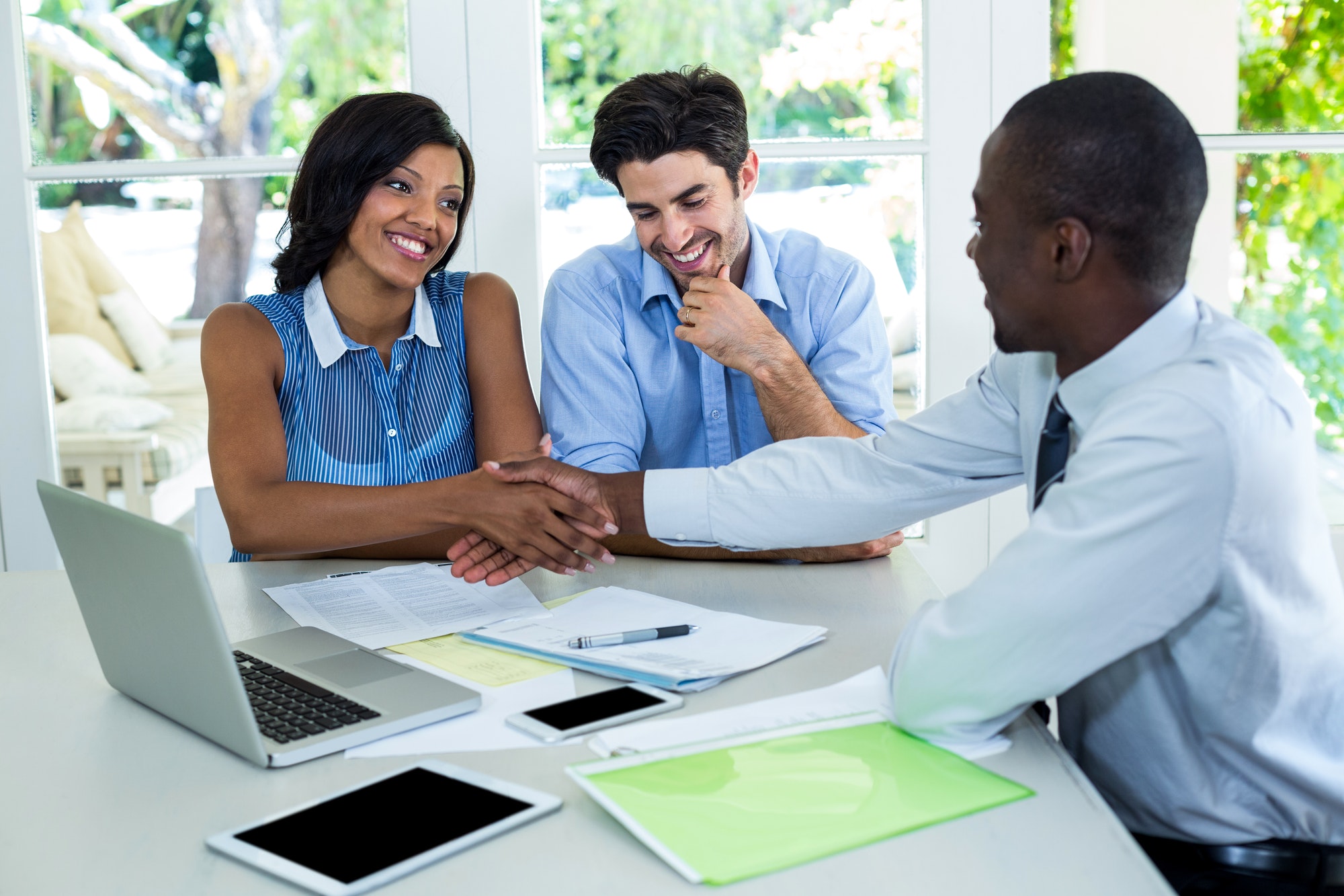 happy-couple-shaking-hands-with-real-estate-agent.jpg